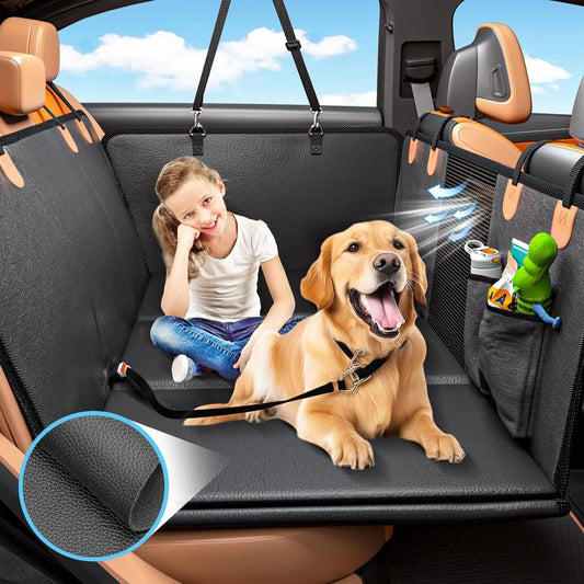 A black car seat cover installed across the back seat of a vehicle, shown with a young girl sitting on the left and a golden retriever dog on the right. The cover includes side pockets holding small toys and a harness attachment point.